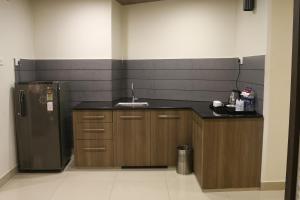 a kitchen with a sink and a refrigerator at The Rubis in Kottakkal