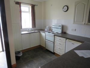 a kitchen with a sink and a stove top oven at Carnside Guest House in Bushmills