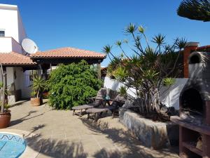 un patio con un grupo de sillas y plantas en El Mayordomo en Corralejo
