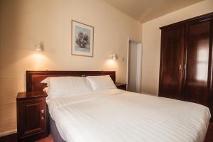 a bedroom with a large bed with white sheets at Villa Nova in Saint Helier Jersey