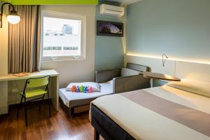 Postel nebo postele na pokoji v ubytování ibis Styles Curitiba Centro Civico