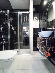 ein Bad mit einer Dusche, einem WC und einem Waschbecken in der Unterkunft S A R O N A ChicLife Design Apt next to the Museum in Bergamo
