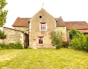 Buxeuil的住宿－CHARMANTE MAISON DE CAMPAGNE DU 17ème siècle à Lilette avec Jacuzzi et proche rivière，一座古老的石头房子,设有红色的窗户和庭院