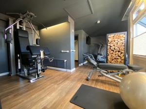 a gym with treadmills and chairs and logs at Hotel Am Schloss Ahrensburg in Ahrensburg