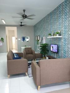 a living room with two couches and a tv at Teratak Mini Pool Homestay Melaka in Melaka