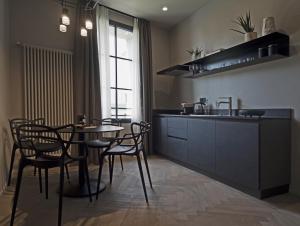 a kitchen with a table and chairs and a sink at Dimora Arco di Mezzo in Battaglia Terme