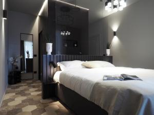 a bedroom with a large bed and a mirror at Dimora Arco di Mezzo in Battaglia Terme