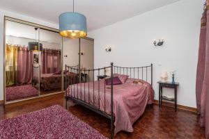 sypialnia z łóżkiem i dużym lustrem w obiekcie Casa dos Pais w mieście Silves
