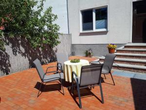 Una mesa y sillas en un patio de ladrillo. en Pension Marina, en Lauta Dorf