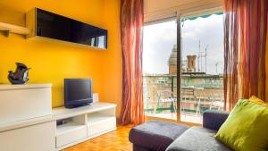 a living room with a tv and a large window at Bed&Bcn Sant Andreu in Barcelona
