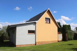 ein kleines gelbes und weißes Haus in einem Hof in der Unterkunft Ferienhaus Krawulski in Hohnstein