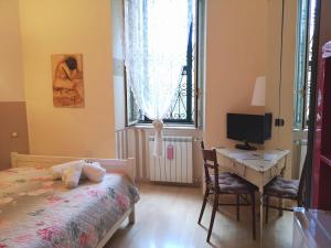 um quarto com uma cama, uma secretária e uma janela em Relais Villa Fiorelli em Roma