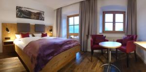 ein Hotelzimmer mit einem Bett, einem Tisch und Stühlen in der Unterkunft Zur Guten Einkehr in Bayrischzell