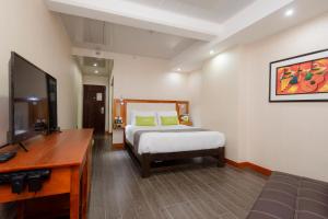 a bedroom with a bed and a flat screen tv at Ayenda La Luna Inn in Lima