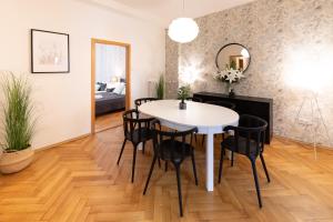 a dining room with a white table and black chairs at Luxury apartment in prime location in Prague