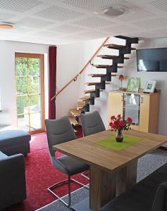 ein Wohnzimmer mit einem Tisch und einer Treppe in der Unterkunft Ferienhaus Krawulski in Hohnstein