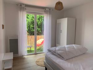 a bedroom with a bed and a large window at Le Chant des Pierres - En Coeur de Ville in Pornic