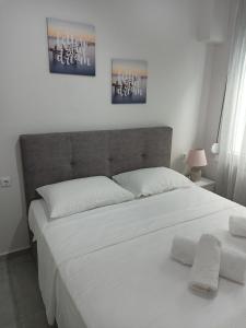 a bedroom with a large bed with two white pillows at Steps to the sea in Nea Peramos