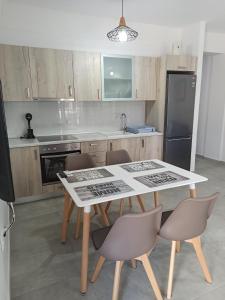 a kitchen with a table and chairs and a refrigerator at Steps to the sea in Nea Peramos