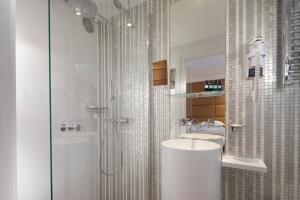 ein Badezimmer mit zwei Waschbecken und einer Glasdusche in der Unterkunft Hôtel R de Paris - Boutique Hotel in Paris