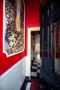 a hallway with a red wall and a painting on the wall at Oude Postkantoor de Rijp in De Rijp