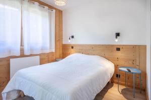 ein Schlafzimmer mit einem weißen Bett und einem Fenster in der Unterkunft BERGERS 1 in Morzine