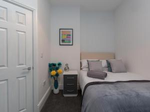 a bedroom with two beds and a vase of flowers at Townhouse @ 166 Ruskin Road Crewe in Crewe