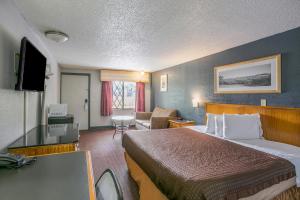 Habitación de hotel con cama grande y escritorio. en Scottish Inns Harrisburg-Hershey South en New Cumberland