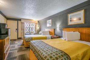 a hotel room with two beds and a television at Scottish Inns Harrisburg-Hershey South in New Cumberland