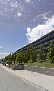 un gran edificio con árboles junto a una calle en Apartment 89 Residence Palace 2 en Sestriere