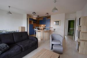 a living room with a couch and a kitchen at 70 m2 avec Balcons et Parking in Lille