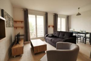 a living room with a couch and a table at 70 m2 avec Balcons et Parking in Lille