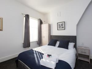 a bedroom with a large white bed with blue pillows at Townhouse @ 83 Edleston Road Crewe in Crewe