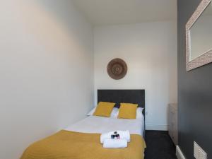 a bedroom with a bed with yellow pillows at Townhouse @ 83 Edleston Road Crewe in Crewe