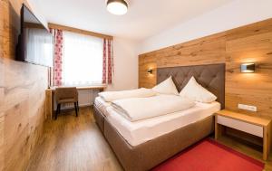 una camera d'albergo con un letto e una scrivania di Alpenhotel Ernberg a Reutte