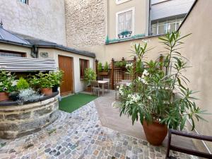 a courtyard with potted plants and a building at Amiral-Fondary in Paris