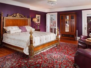 a bedroom with a king sized bed and a red carpet at Abbeymoore Manor in Victoria