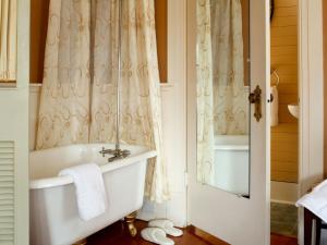 a bathroom with a bath tub and a sink at Abbeymoore Manor in Victoria