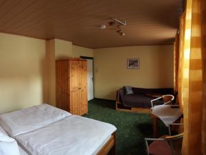 een slaapkamer met een bed, een bank en een stoel bij Gasthaus "Zur Linde" in Harzgerode