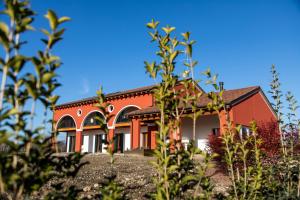 czerwony dom z niebieskim niebem w tle w obiekcie Agriturismo Da Zeffi w mieście Spresiano