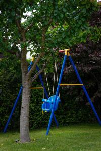 a blue swing set next to a tree at Seo Rewal in Rewal