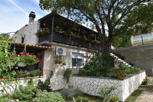 ein Haus mit einem Balkon mit Blumen darauf in der Unterkunft Vacation home Vesna in Bribir