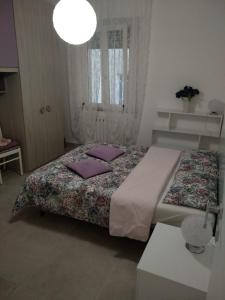sypialnia z łóżkiem z fioletowymi poduszkami w obiekcie Angel B&B w mieście Potenza Picena