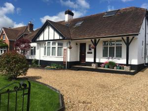 a white and black house with a gravel driveway at Spurwing Guest House in Wareham