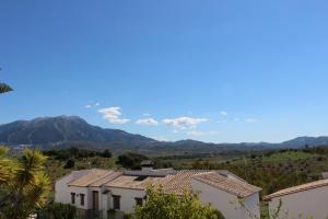uma vista para uma casa com montanhas ao fundo em Alojamientos Huetor em Viñuela
