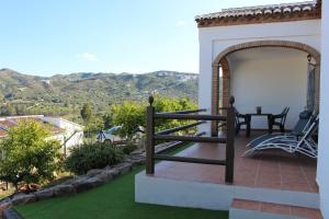 een patio met een tafel en uitzicht op een berg bij Alojamientos Huetor in Viñuela