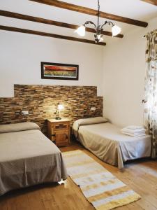 オルヒバにあるポサダ アルプハラ ソルのレンガの壁、ベッド2台が備わるベッドルーム1室が備わります。