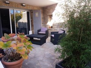 un patio con sillas, mesa y plantas en Ambition Zen Presles en Presles