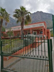 an orange building with palm trees in front of it at Casa Hokie in Colonia de Sant Pere