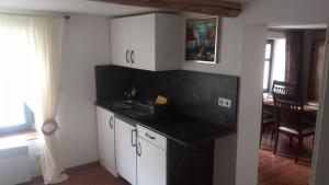 a kitchen with white cabinets and a black counter top at Altstadt Apartments in Querfurt